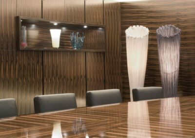 Konferenzraum mit Tisch und Wandverkleidung aus glänzendem dunklen Holz